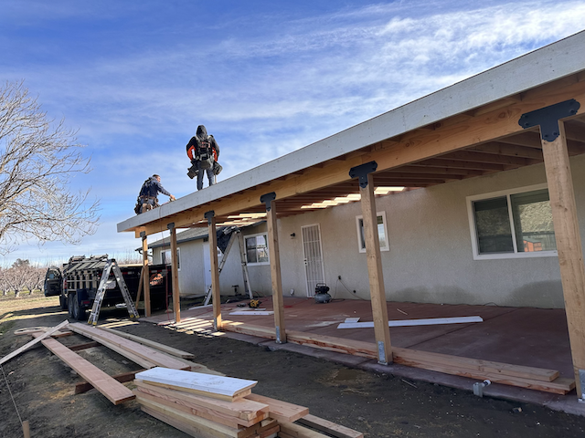 Zinc Roofing crew building a custom patio cover, installing a new roof, and remodeling the exterior of a home in Fresno.